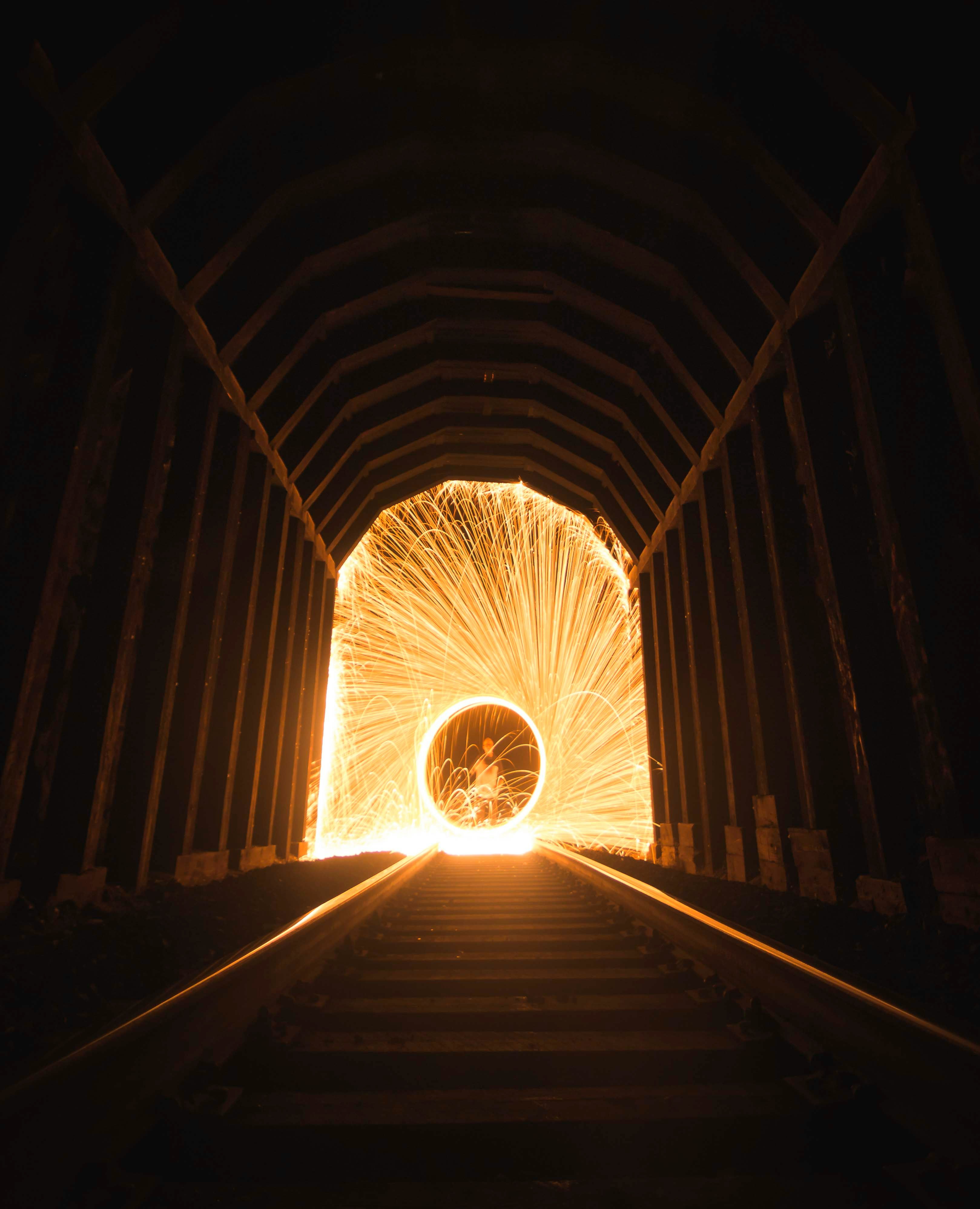 time lapse photography of steel wool fireworks inside tunnel